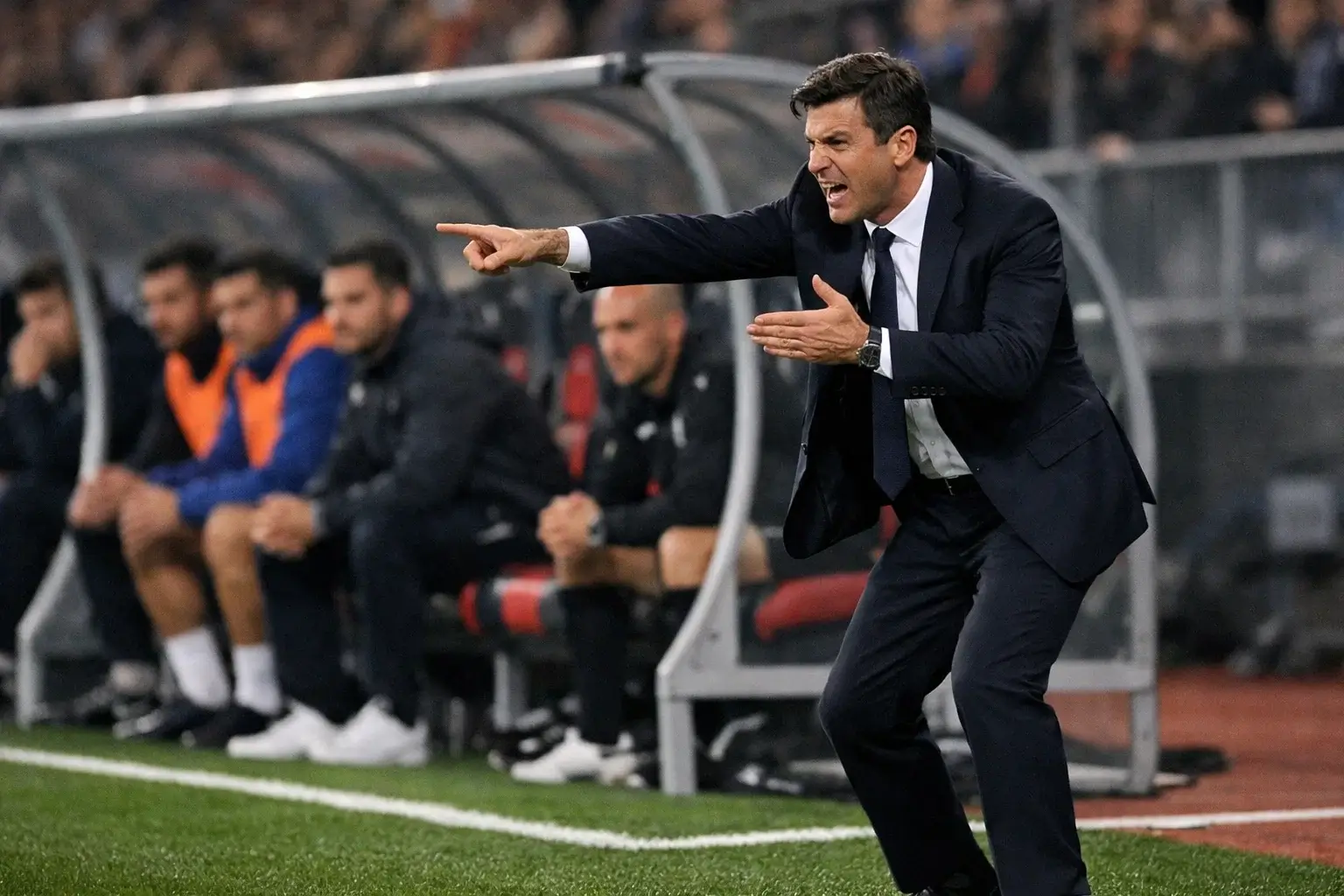 Entrenador de fútbol dando instrucciones tácticas a sus jugadores desde la banda